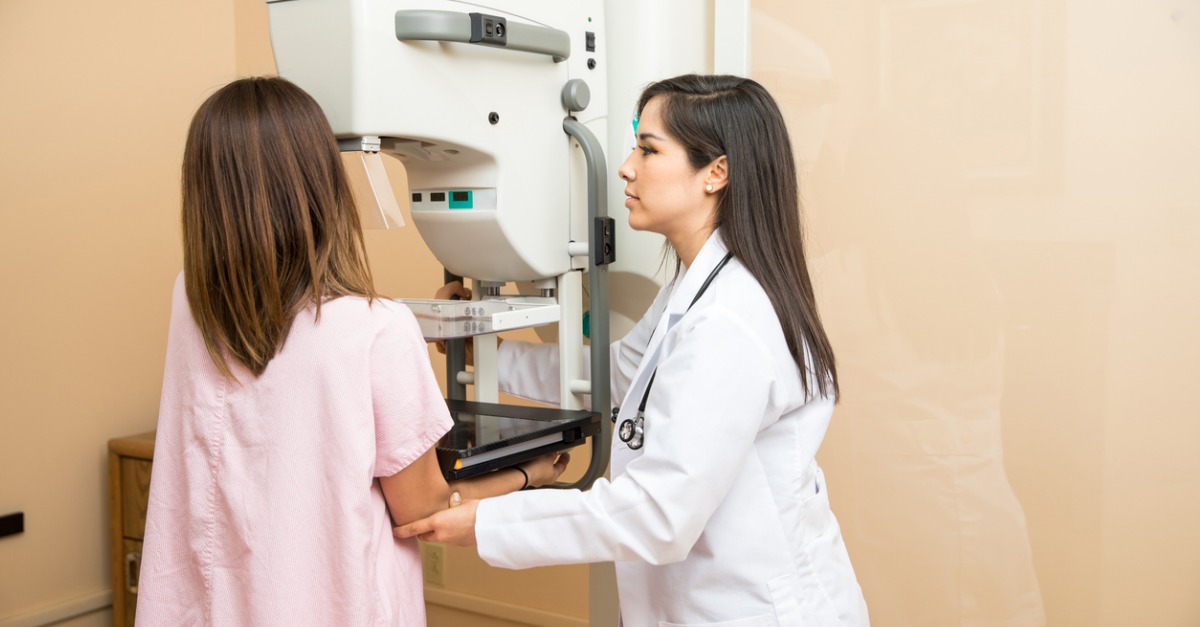Doctor helping patient get a mammogram