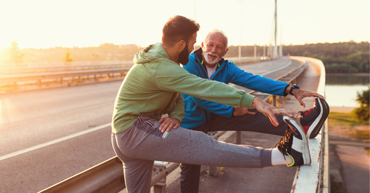 Father and son stretching their legs during an outdoor exercise.