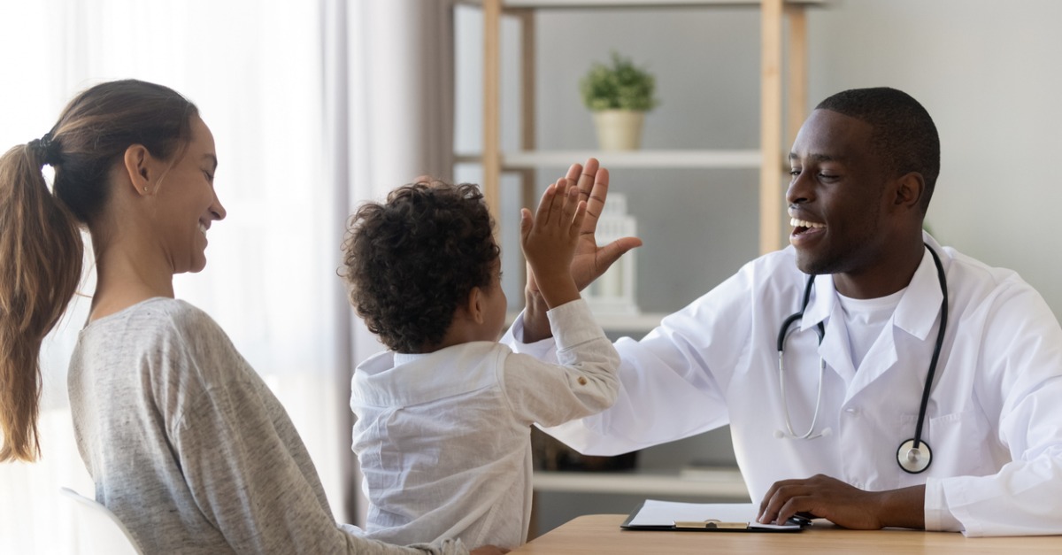 little boy patient give high five to doctor at checkup