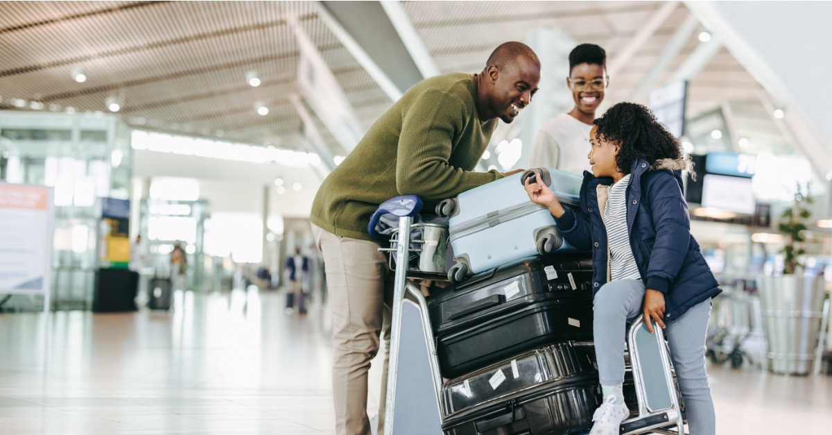 tourist family with luggage trolley at airport