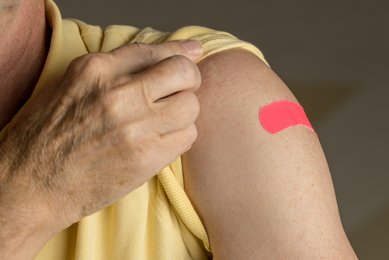 Person showing bandaid on arm.