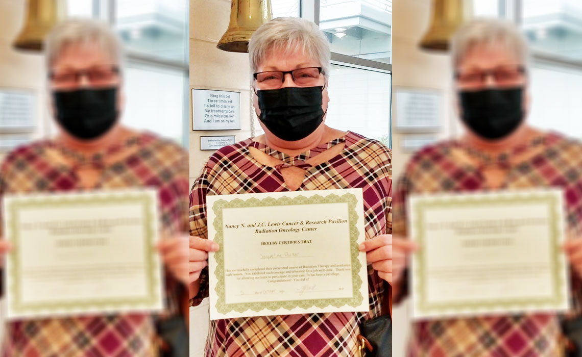 Jackie Parker holding up a certification that congratulates her for completing radiation therapy successfully.
